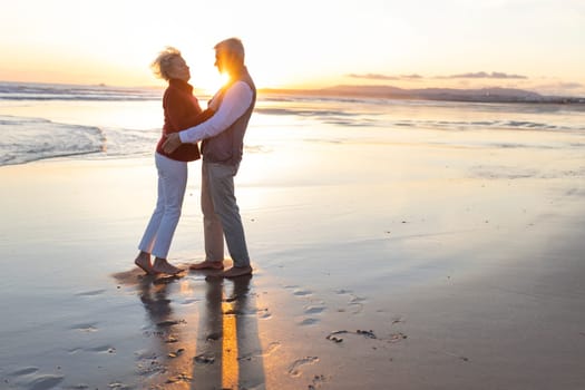 Senior couple enjoying a romantic moment on the beach at sunset