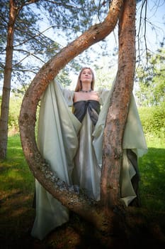 Beautiful dryad or fairy near trees. Pagan spirit of forest. Environmental friendliness, caring for nature. Adult mature woman 40-60 in Photo shoot