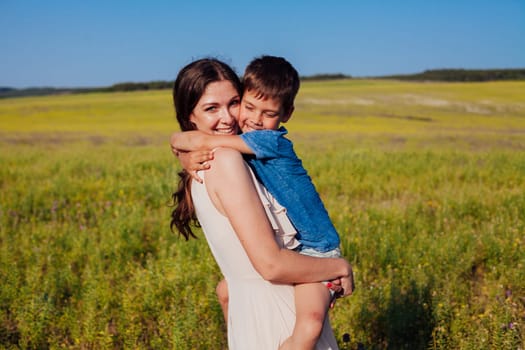 Mother and young son walking in a rural field in summer