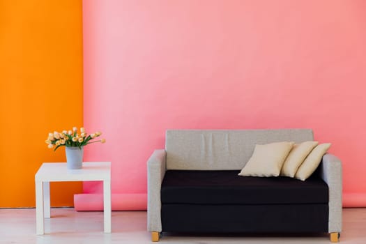 Gray office sofa with table in the interior of a yellow orange room