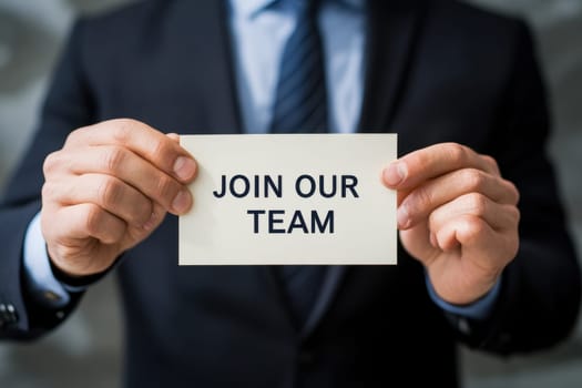 business man holding paper card with join our team text..