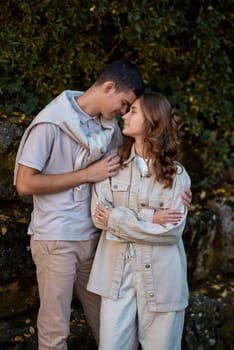 Young Cute Female Hugs Boyfriend. In Autumn Outdoor. Lovers Walking in Park. Attractive Funny Couple. Lovestory in Forest. Man and Woman. Cute Lovers in the Park. Family Concept. Happy Couple.