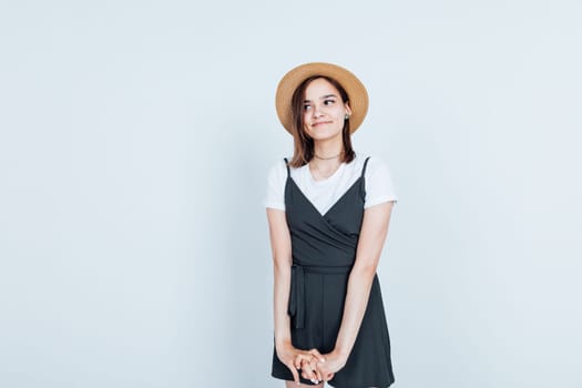 Beautiful slim fashion woman in sundress and hat smiling on white background