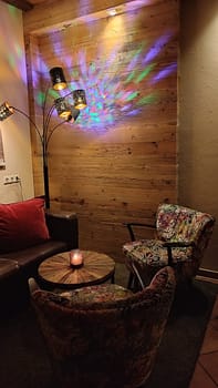 Cozy colorful corner table restaurant objects chear sits night light evening furniture objects building architecture design decor decorations indoor house interior lights lamp . High quality photo