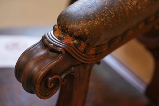 A wooden antique leather carved armchair