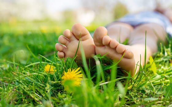 child feet in a garden with dandelions. Selective focus. kid,