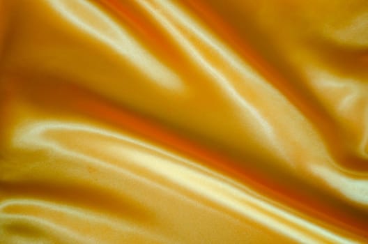 Top view of golden yellow silk cloth with silky sheen suitable for design and wallpaper background.