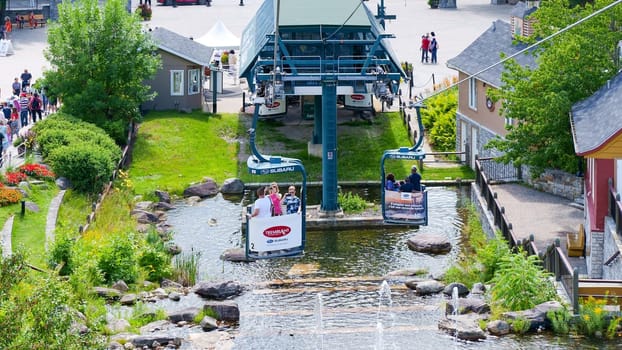 Mont-Tremblant QC Canada - 22.09.2024: A Scenic Chairlift Ride Over a Sparkling River in a Vibrant Village Surrounded by Lush Nature.