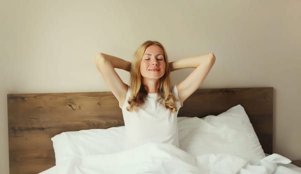 Healthy sleep, relaxed woman wakes up lying on white bed in bedroom at home