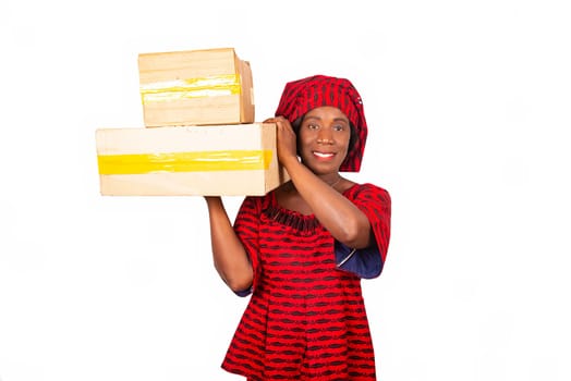 beautiful african adult woman dressed in red loincloth standing holding boxes of cards smiling on the side. isolated on white background