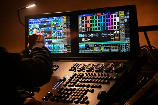 France, April 2025: A skilled technician adjusts lighting settings on a digital control board, contributing to the electrifying ambiance of a live concert at a popular venue.