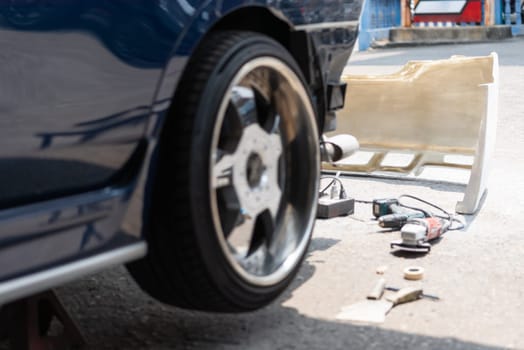Denter or car mechanic serviceman check and fix body work and fiber bumper body part for fix and repair problem at car garage or repair shop