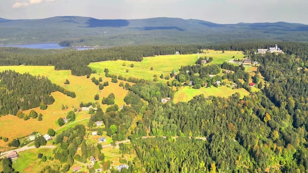A stunning aerial view of vibrant green fields, lush forests, and serene landscapes in all directions