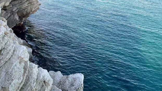 The stunning view features majestic cliffs by the crystalclear sea and a vibrant city skyline in the background
