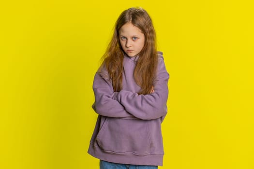 Offended sad nervous young preteen child girl kid having misunderstanding, frustrated after quarrel, fail, lose, ignores and does not want to communicate, talk. Children isolated on yellow background