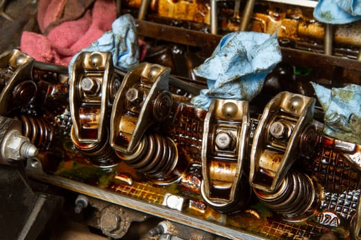 A close up of the engine of a car with the oil and grease visible. The engine is in need of repair