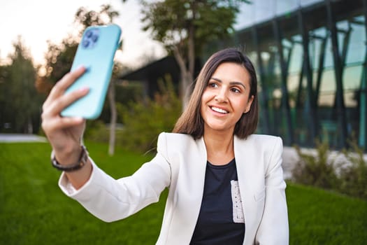 Businesswoman taking selfies on a phone after work.