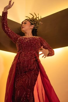 Princess wearing a red dress with the gold crown on her head in front of the lighting in the background