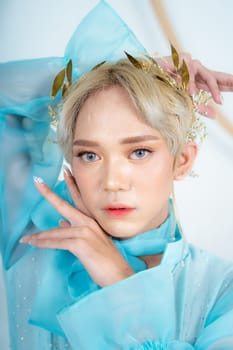 a royal princess in a blue dress posing with her hands very elegantly in a white palace