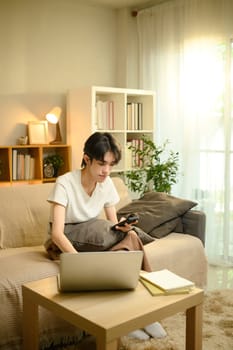 Relaxed man using technology for work or study in cozy living room.