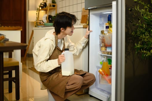 Man taking milk from refrigerator in kitchen while preparing breakfast.
