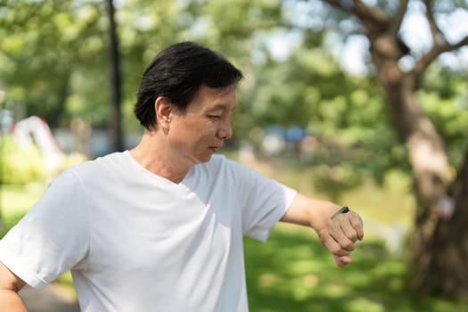 A man examines his smartwatch while enjoying a moment outdoors, emphasizing the importance of wellness and fitness tracking.