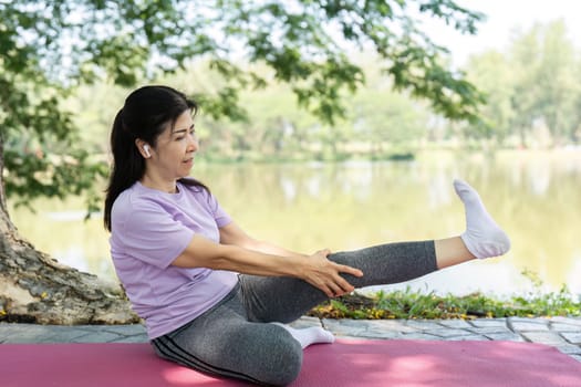A woman engages in yoga stretches near a serene lake, promoting wellness and mindfulness in nature.