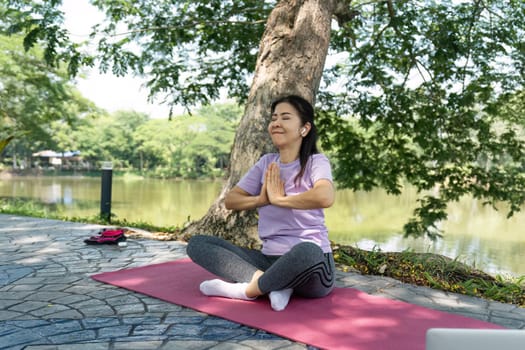 A woman performs a gratitude meditation in a serene outdoor setting, promoting wellness and inner peace.