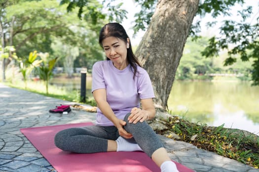 A woman engages in a focused yoga stretch, enhancing her wellness routine by a peaceful lakeside.