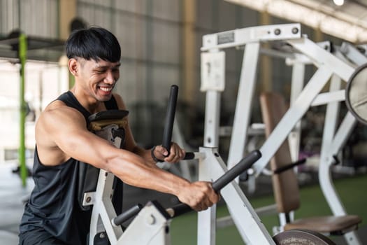 A male athlete passionately works out on gym equipment, focusing on strength training and fitness goals.