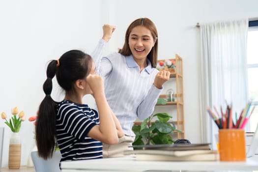 A teacher celebrates a student's achievement with excitement, showcasing the joy of learning and mentorship.