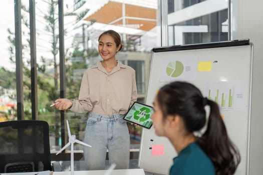 A young professional presents ESG data on a tablet during a business meeting, promoting sustainability and corporate responsibility.