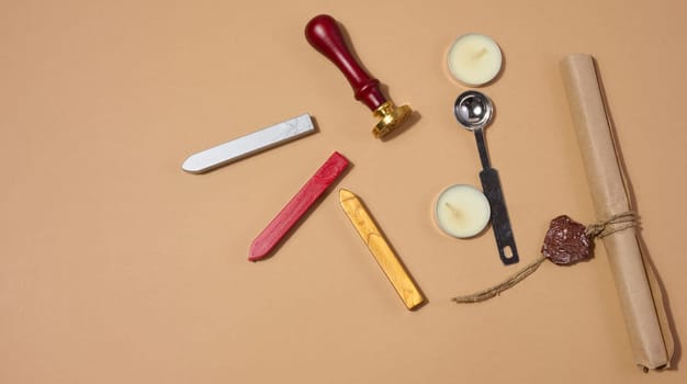 A wax seal kit including wax sticks, spoon, candles, stamp and sealed scroll placed on a neutral background