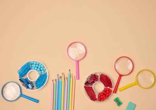 Various office and school supplies, including pencils, magnifying glasses, paper clips and pins, are neatly arranged on a neutral background.