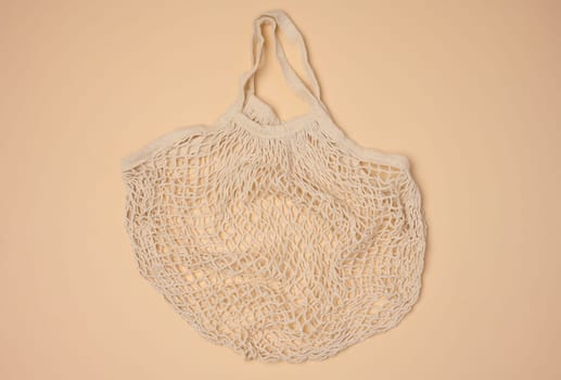 Empty reusable cotton mesh bag on neutral background, top view
