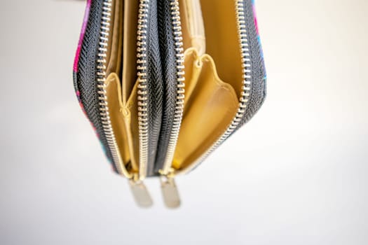 Fashionable outdoor women's empty wallet with gold zippers, top view, on white background.