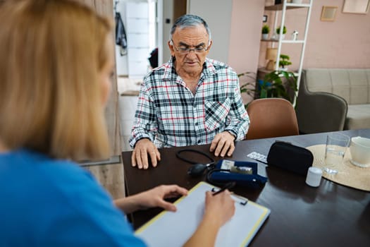 Health professional conducts a checkup with an elderly client.