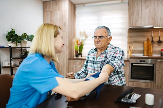 Nurse checks vital signs of senior patient at home.