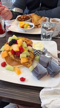 Ottawa, ON Canada - 10.01.2024: Delicious Breakfast Platter with Fresh Fruit, Waffle, and Pancakes at a Restaurant Table