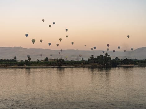 Many balloons in the sky over Nile River in Luxor for sunset flight over the Valley of the Kings