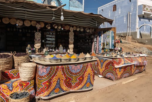 Bowls of spices on colorful cloth inn store selling artifacts for tourists in Nubian Village near Aswan, Egypt