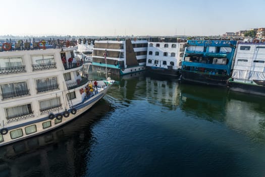 Edfu, Egypt - 6 November 2024: Cruise ships docked side by side in congested Edfu harbor Egypt