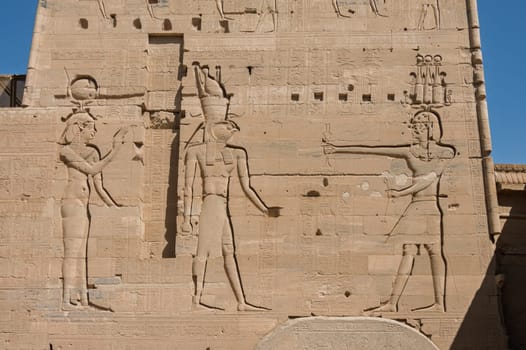 Detail of the bas-relief carving of the Isis and Horus facing Pharoah in the reconstructed Philae Temple in Aswan Harbor in Egypt