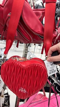 Ottawa, ON Canada - May 01, 2025: Stylish red heart-shaped handbag with Aldo logo displayed in a retail store, showcasing modern design and luxury accessories for fashion enthusiasts and shoppers.