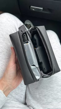 Ottawa, Canada - April 05, 2025: A hand grips a DJI Osmo Pocket 3 camera, resting on a lap with a sleek black carrying case, highlighting innovative design for capturing steady videos