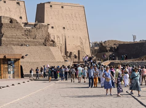 Edfu, Egypt - 6 November 2024: Many tourists walking towards the massive temple in Edfu dedicated to Horus and Hathor