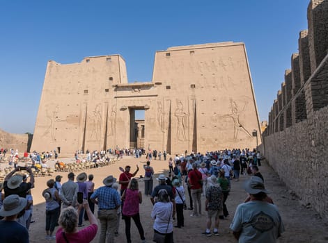 Edfu, Egypt - 6 November 2024: Many tourists walking towards the massive temple in Edfu dedicated to Horus and Hathor