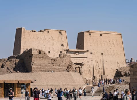 Edfu, Egypt - 6 November 2024: Many tourists walking from the massive temple in Edfu dedicated to Horus and Hathor