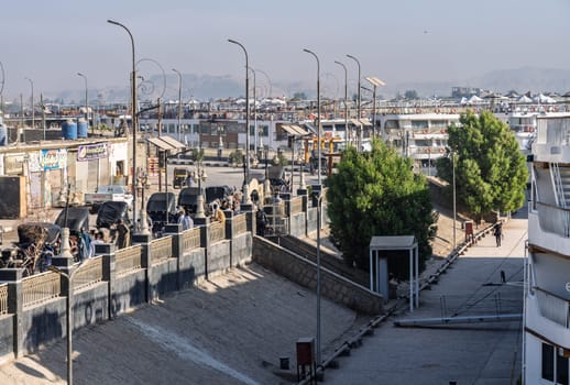 Edfu, Egypt - 6 November 2024: Cruise ships docked side by side with horses and carriages waiting in congested harbor