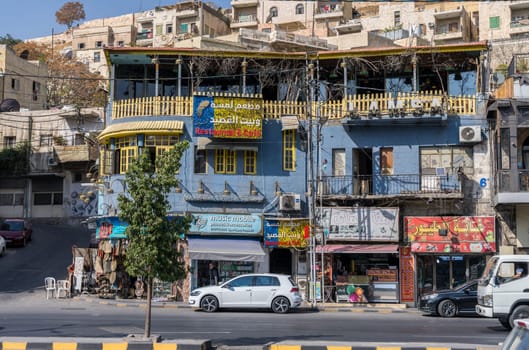 Amman, Jordan - 12 November 2024: Busy commercial block in downtown with shops and restaurants on hillside